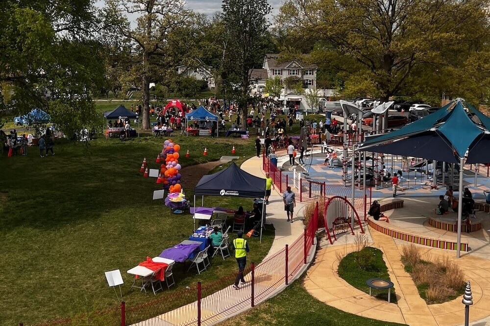 A view of a park with several tents and groups of people