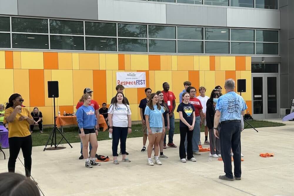 A group of 15 students from Albert Einstein High School singing outside