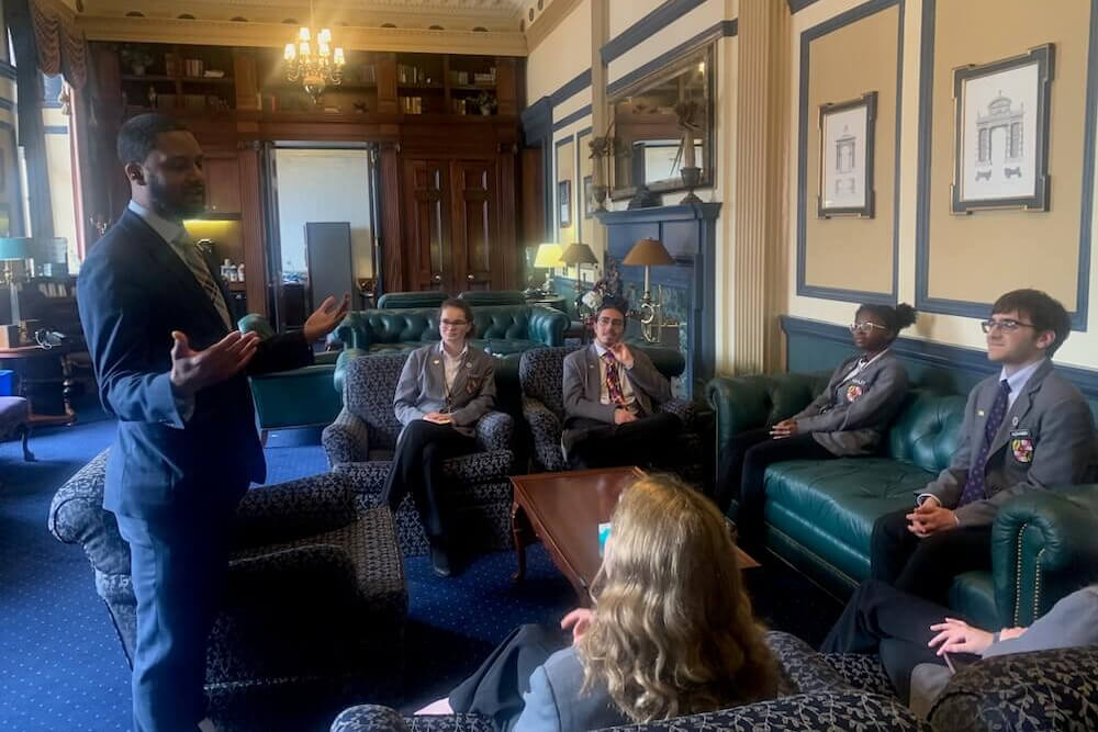 A delegate speaks to a group of Student Pages