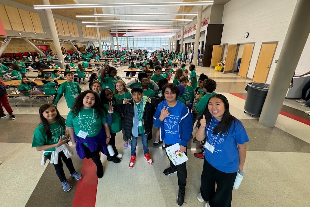 A large group of students smile for a photo during lunch
