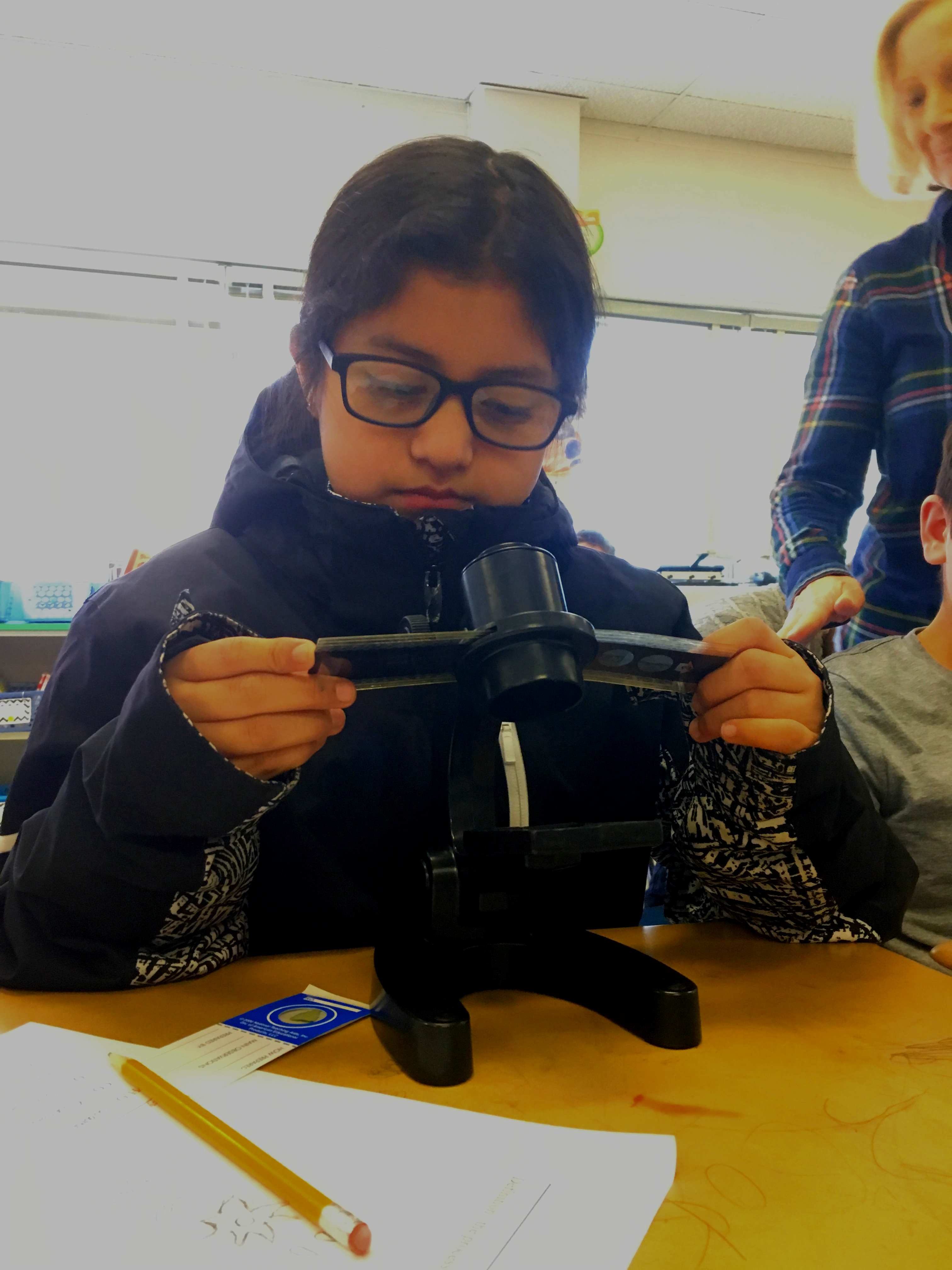 Girl on microscope